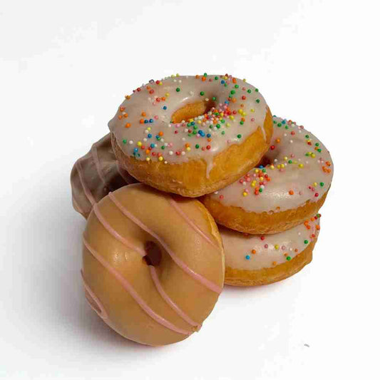 Vanilla and caramel mini doughnuts stacked.