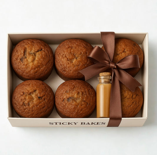 Sticky date pudding with butterscotch sauce in a white box. 